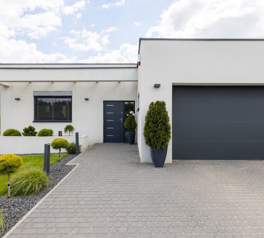 Outside view of elegant suburban house with big window green lawn